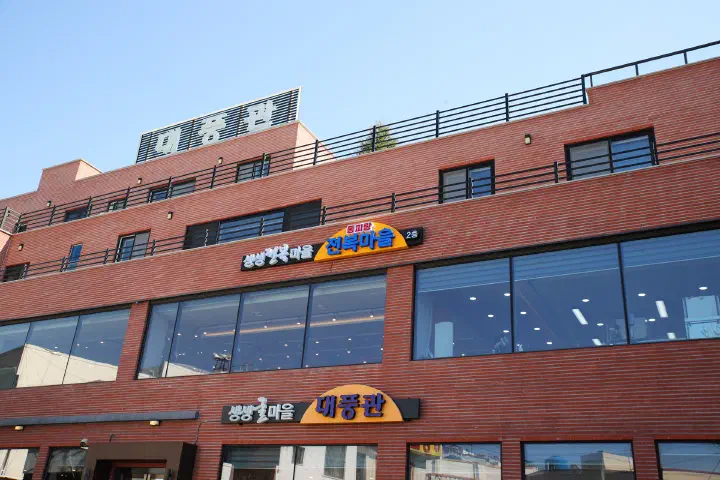 통영 동피랑전복마을이 입점한 대풍관 건물 외관과 2층 전복마을 간판
