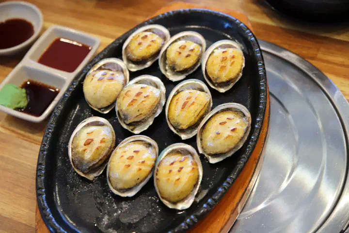 칼집 넣어 버터에 구운 동피랑전복마을 전복버터구이, 껍질째 철판에 올린 통통한 전복