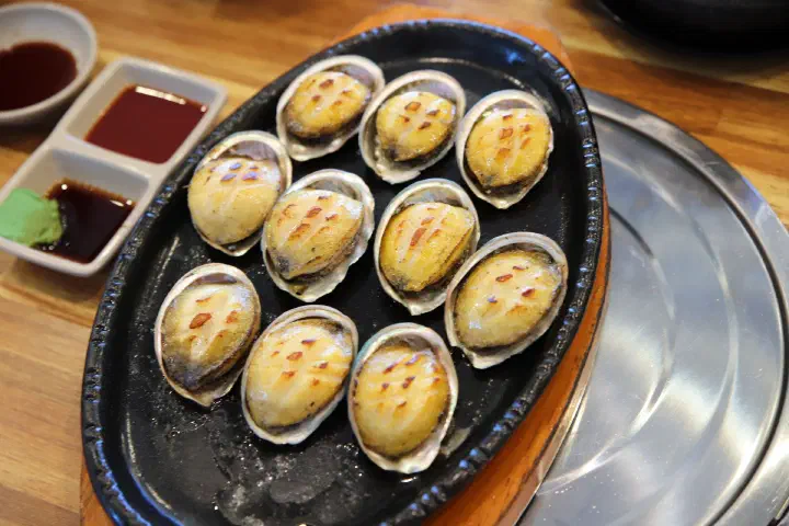 칼집 넣어 버터에 구운 동피랑전복마을 전복버터구이, 껍질째 철판에 올린 통통한 전복