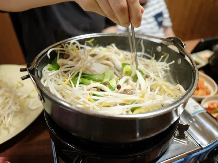 Knife-cut noodles cooking in the shabu-shabu broth at Cheonghakdong Eonyang Bonjeom
