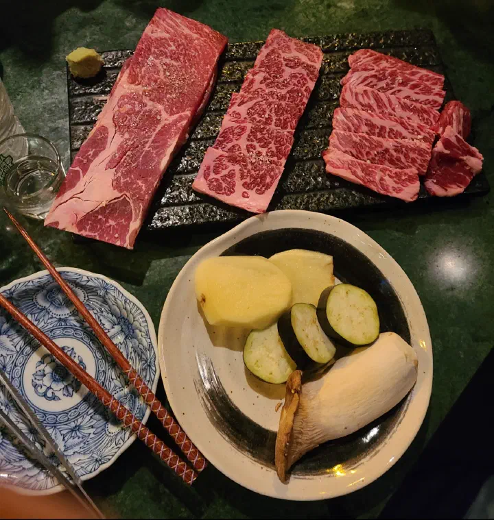 Raw marbled Hanwoo cuts with grilling vegetables at Eunsincheo