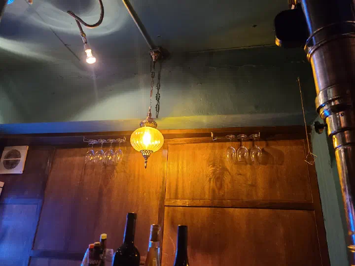 Cozy interior of Eunsincheo with a vintage pendant lamp and hanging wine glasses