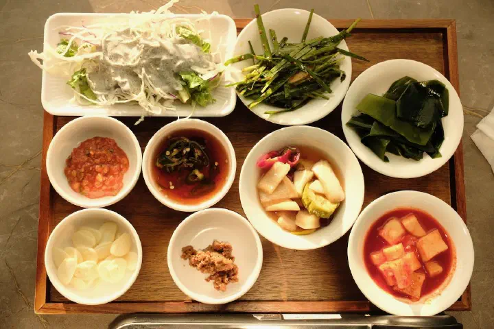 고담식당 기본 반찬 상차림, 양배추 샐러드와 미나리무침 등