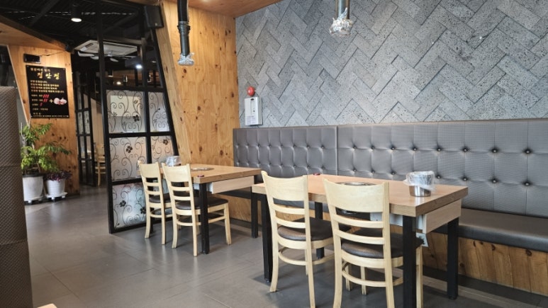 Jeonganjeong dining hall with four-seat tables and a herringbone stone wall
