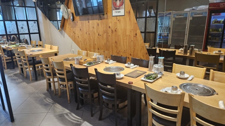 Long group-seating tables at Jeonganjeong with kimchi refrigerators on the side