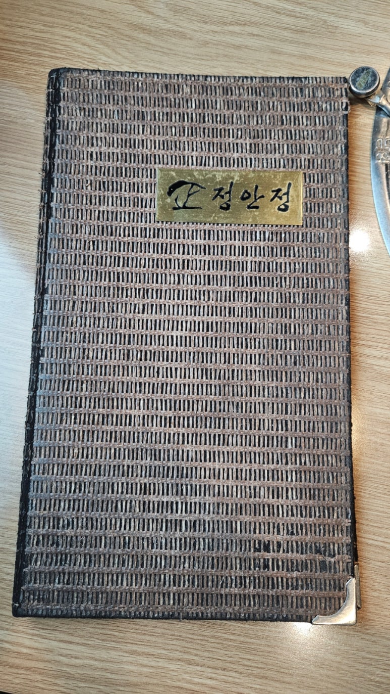 Wooden Jeonganjeong menu cover with the restaurant&rsquo;s gold logo