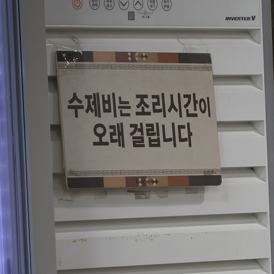 Sign on the restaurant wall saying sujebi takes a long time to cook