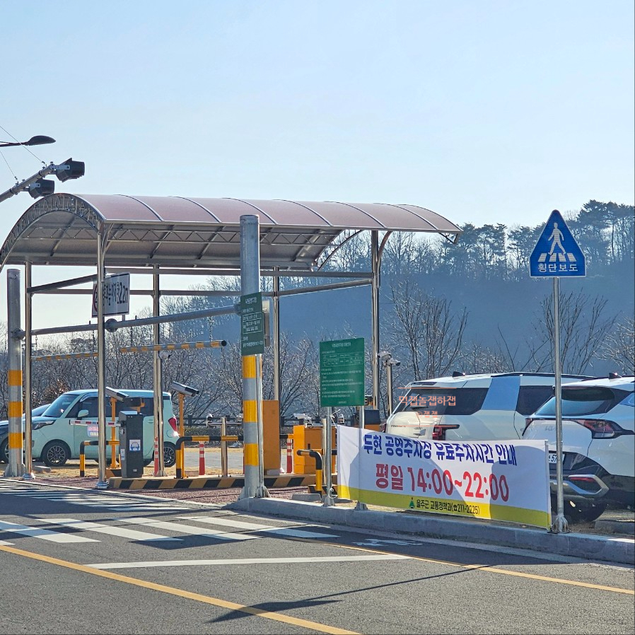 Duhyeon public parking lot entrance and parked cars near the restaurant
