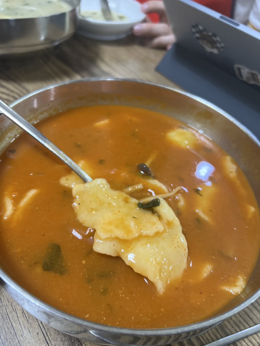 Full bowl of spicy sujebi with a dusting of sancho pepper on the surface