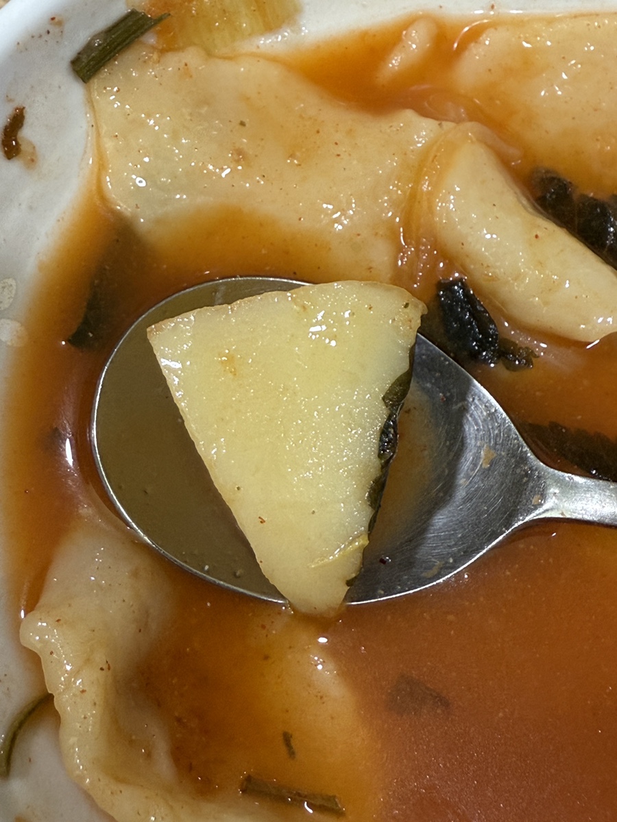 Slice of soft potato in the sujebi bowl on a spoon