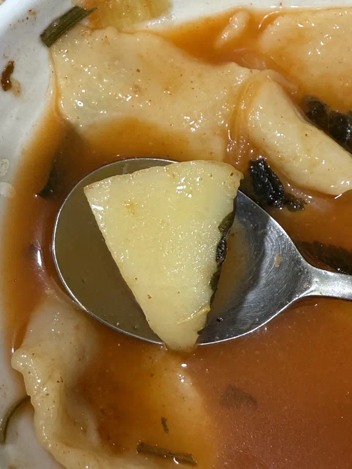 Slice of soft potato in the sujebi bowl on a spoon