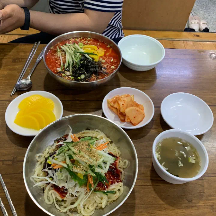 Bibim kalguksu served with a side of warm broth