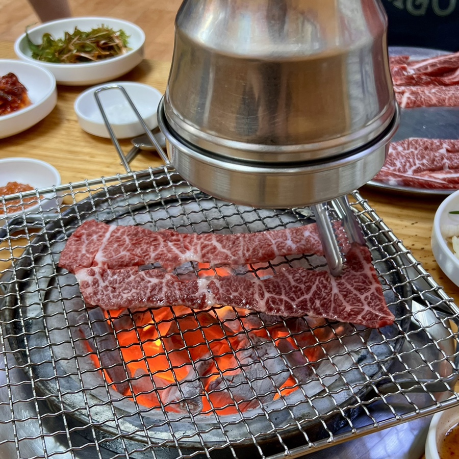 Hanwoo galbisal cooking over real charcoal on a wire grill