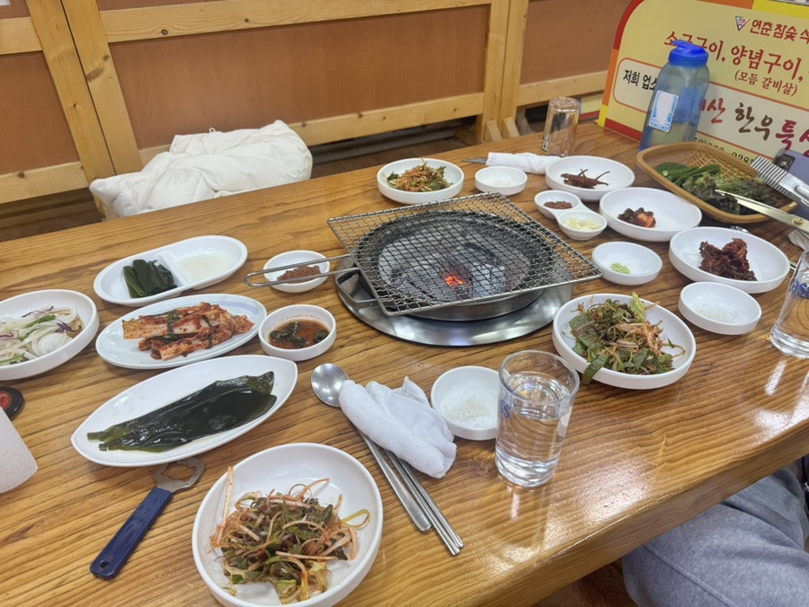 Full table setting at Yeonchun, with grill ready and side dishes spread out