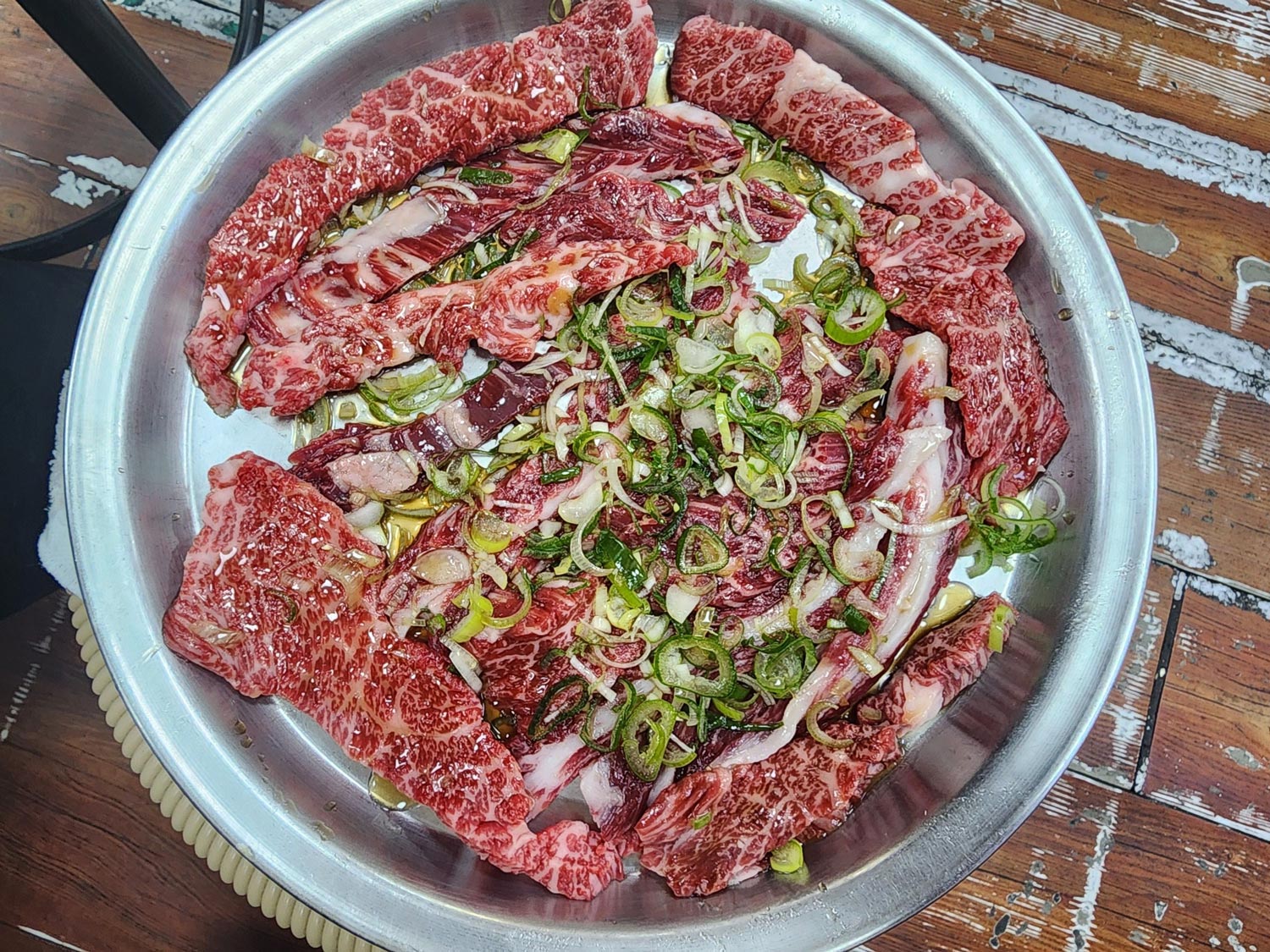 Raw Hanwoo galbisal marinated with soy and green onion, ready to grill