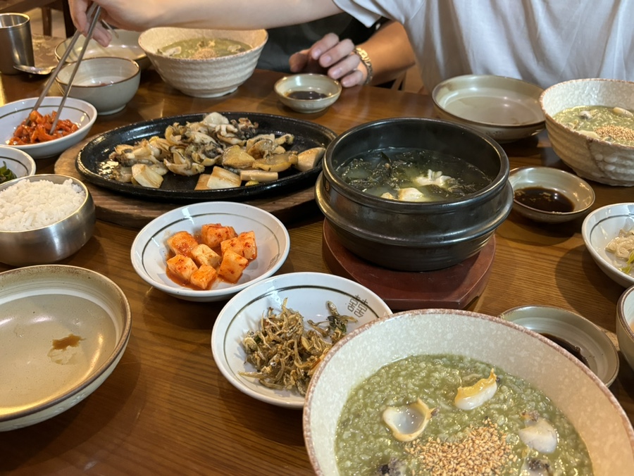 Full feast table at Wonjo Jeonbokjuk with multiple abalone dishes