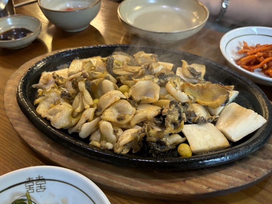 Butter-grilled abalone on a sizzling iron plate at Wonjo Jeonbokjuk