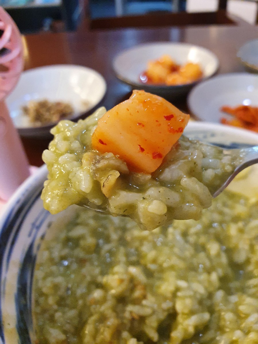 Porridge with a piece of kkakdugi on top at Wonjo Jeonbokjuk