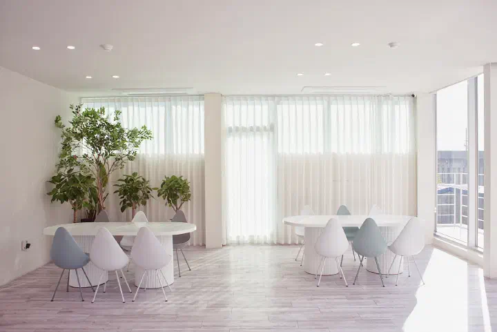 Bright white second-floor seating with full-height windows at Neutinamu-ui Sarang Cafe