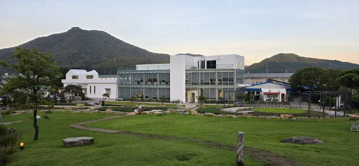 양산 느티나무의사랑카페의 잔디 정원과 통창 2층 카페 건물 전경