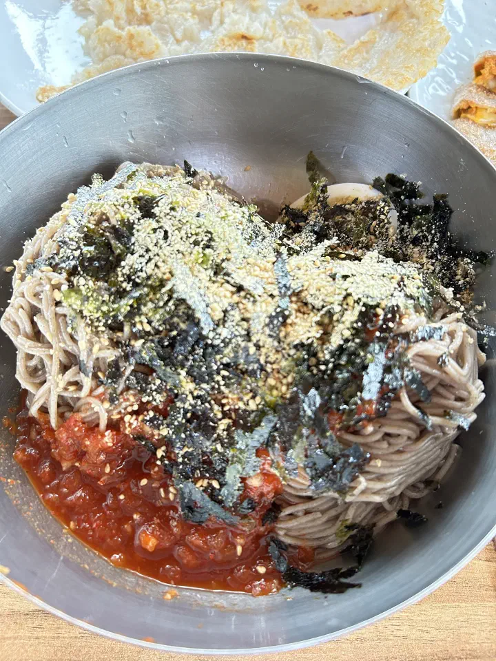 Close-up of grey buckwheat noodles with sesame, seaweed and red chili sauce at Yeonggwangjeong Memil Guksu