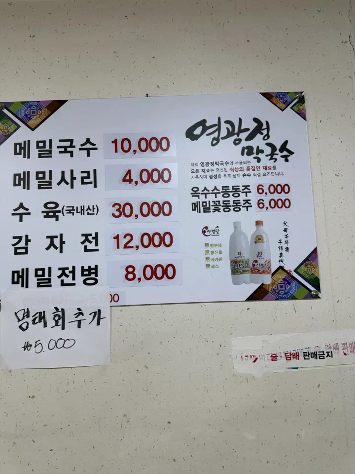 Korean-only price list on the wall showing memil guksu at 10,000 won and suyuk at 30,000 won