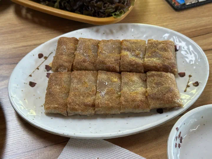 Plate of sliced memil jeonbyeong buckwheat crepe rolls at Yeonggwangjeong