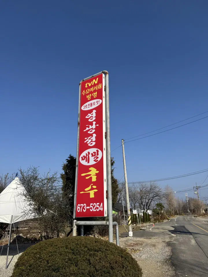 Tall red roadside sign for Yeonggwangjeong Memil Guksu on Jinmi-ro in Ganghyeon-myeon, Yangyang