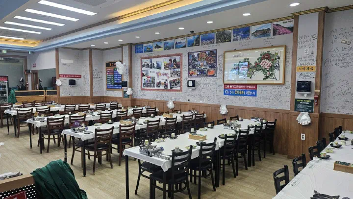 Spacious dining hall with group tables at Hwangso Sikdang