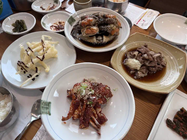 Crab soybean paste stew, bulgogi and gat kimchi on the kkotge set table