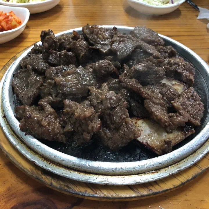 Close-up of Sobok Galbi Korean beef ribs served on a stone plate