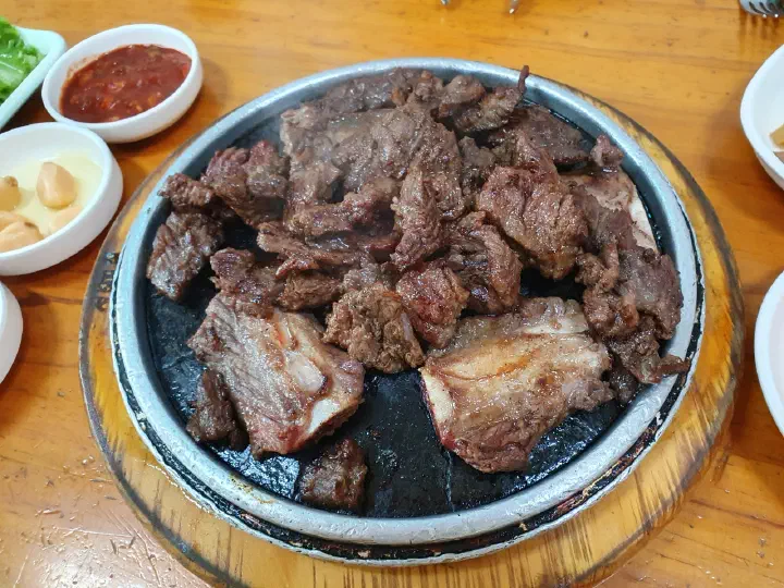 Close-up of yangnyeom galbi on a heated stone plate at Sobok Galbi