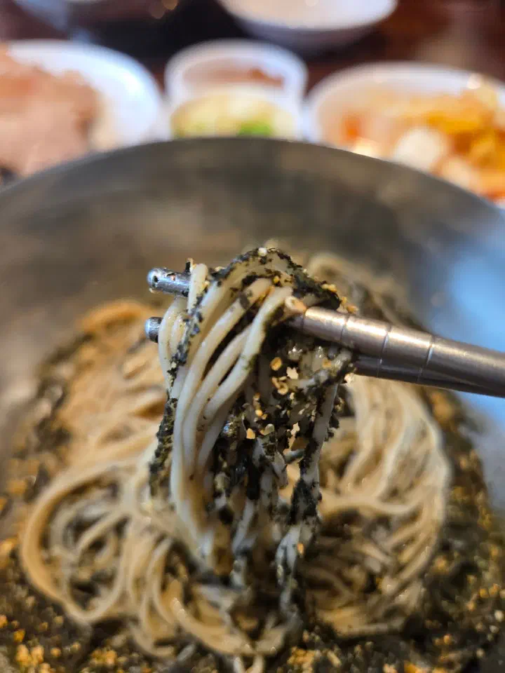 Close-up of 100% buckwheat noodles tossed with perilla oil and seaweed flakes at Gogiri Makguksu