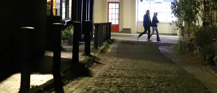 Two people walking together on a quiet city street in the evening