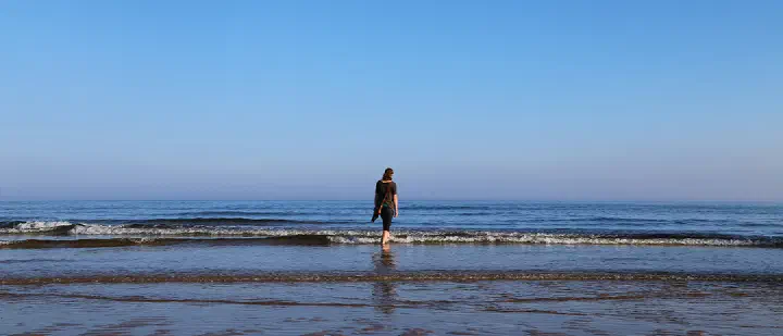 Person walking toward the sea and uncertain future