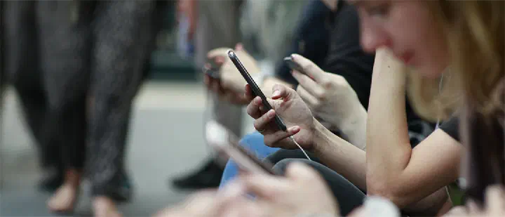 People focused on their smartphones, a common scene of social media usage