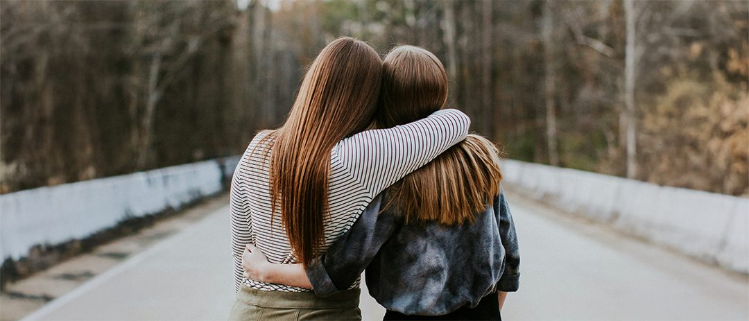 Two people walking together with arms around each other, symbolizing trust and relationship
