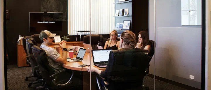 A team collaborating and working together in a meeting room, symbolizing trust and teamwork