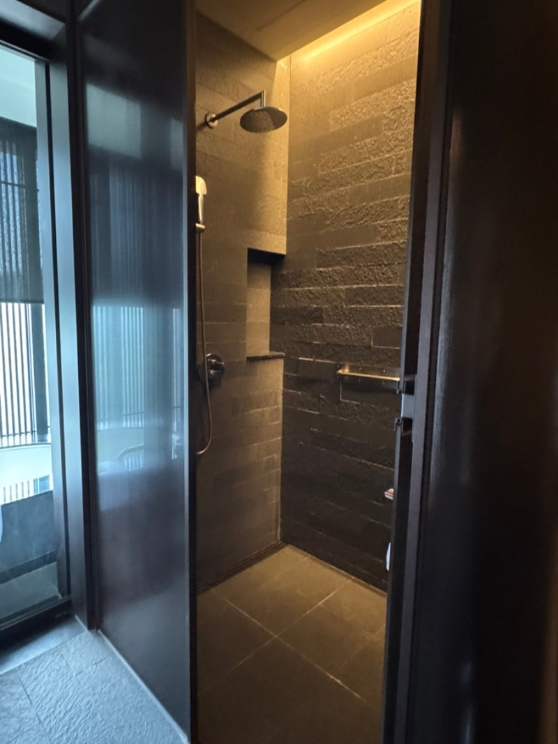 Independent shower booth with stone-textured walls