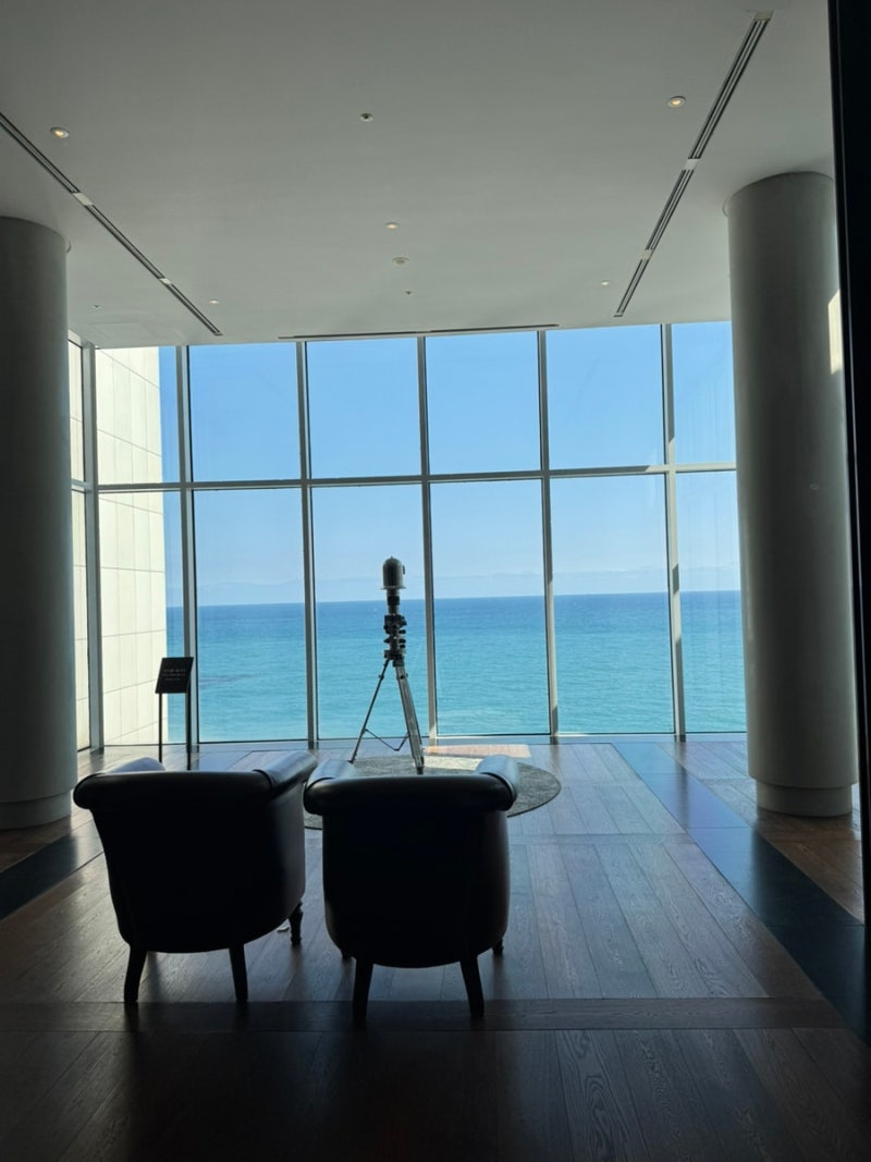 Busan ocean view through the 10th-floor lobby’s floor-to-ceiling windows at Ananti Cove