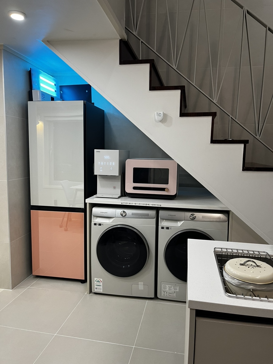 Water purifier, fridge, and laundry area inside the Villa de Himmel room