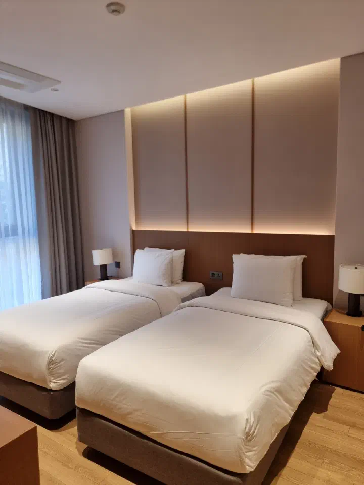A Forest Resom guest bedroom with twin beds and a wood-tone headboard