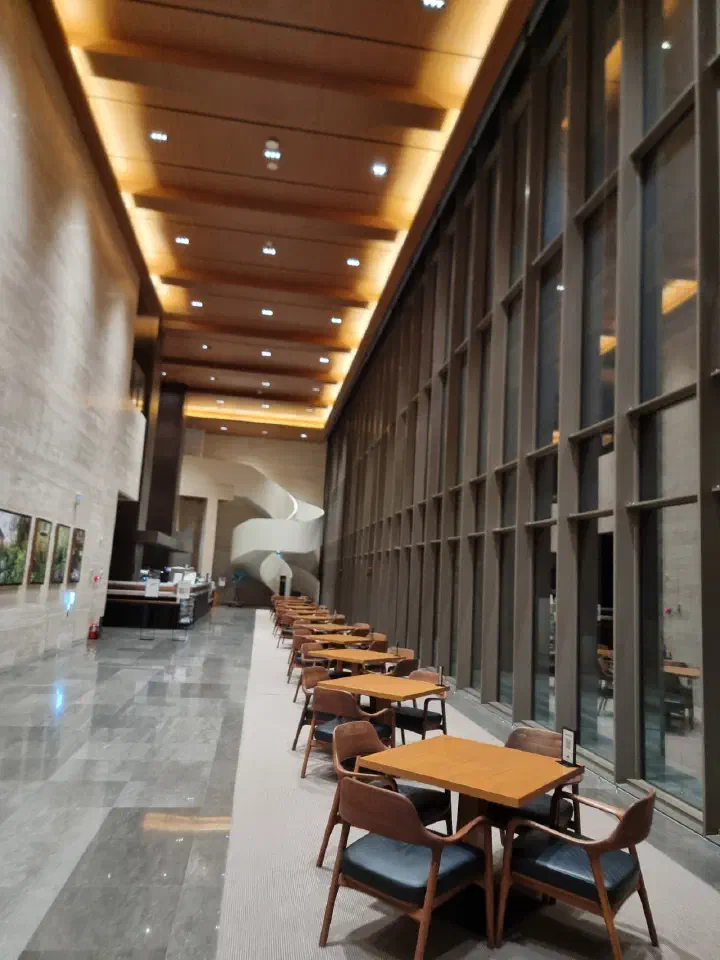 The Restri lobby cafe lounge at Forest Resom with floor-to-ceiling windows and wooden tables