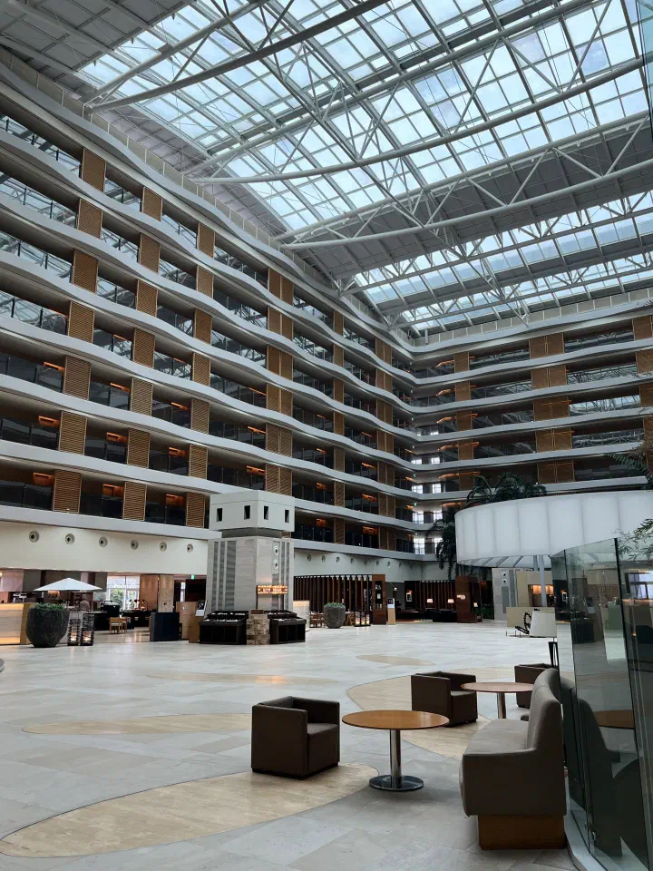Daytime view of the sunlit Haevichi Hotel Jeju atrium lobby and lounge seating