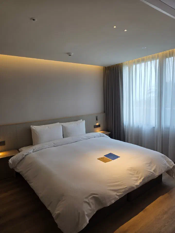 King-size bed and wood-toned interior in a Haevichi Resort Jeju bedroom