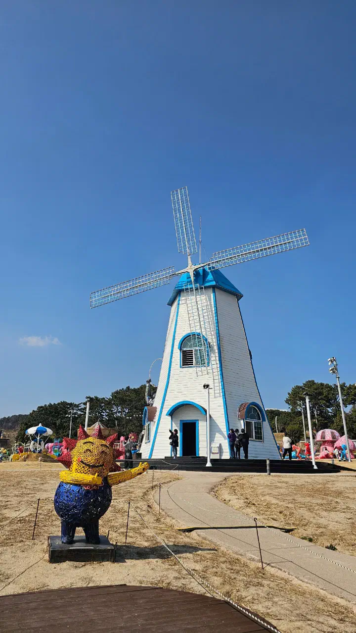 The Ganjeolgot lighthouse and a white windmill in one view